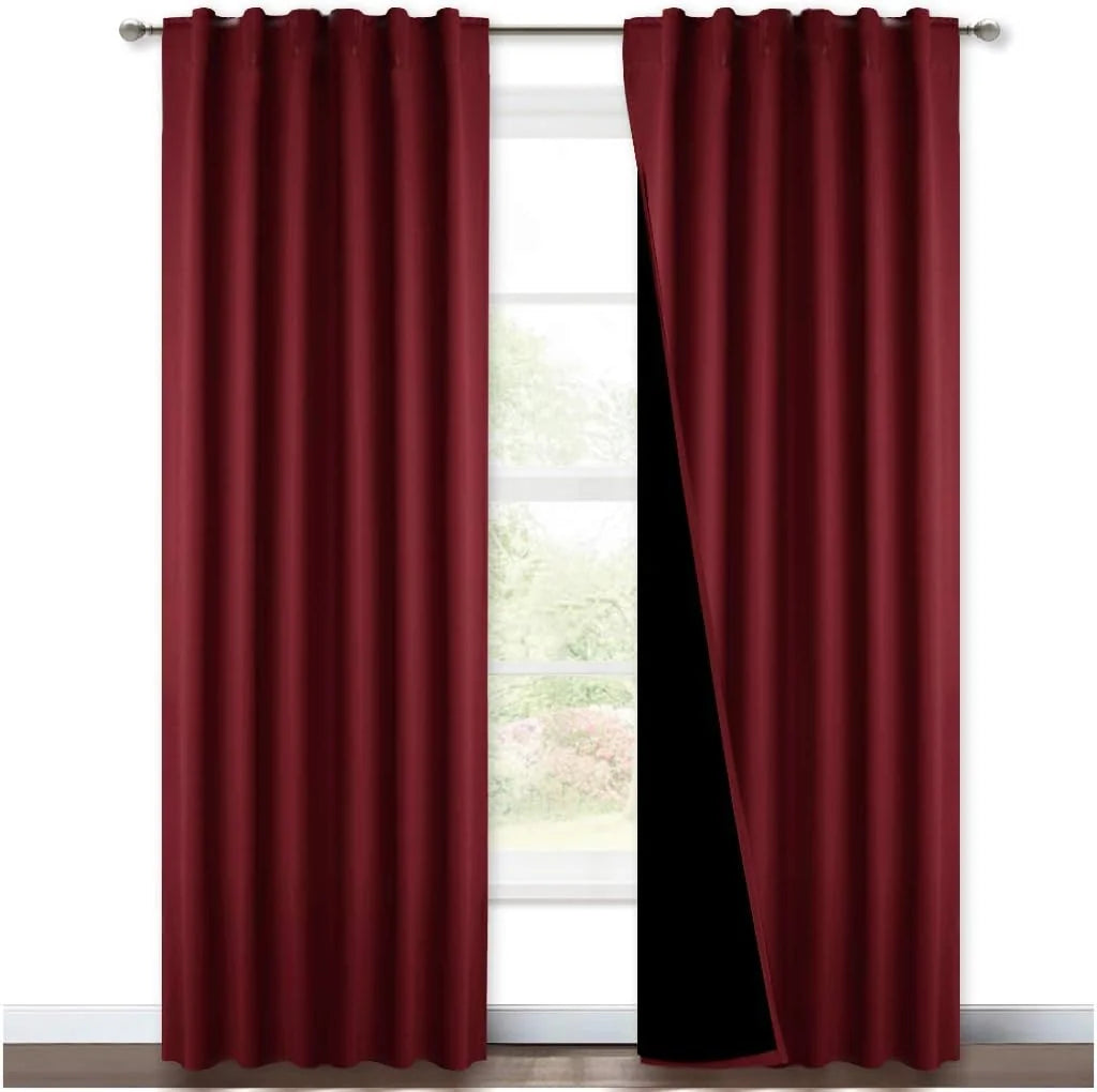 Burgundy blackout curtain panels with rod pocket top hanging on a silver curtain rod