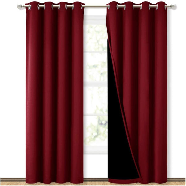 Pair of burgundy blackout grommet curtains on a rod. One panel is open, showing a thick black lining against a window.