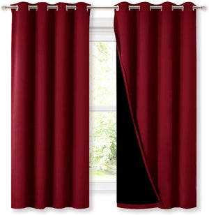Pair of burgundy blackout curtains with silver grommet tops, one showing dark insulating lining.