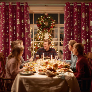 Burgundy curtains with gold Christmas tree and snowflake patterns. Grommet top. Festive holiday decor.