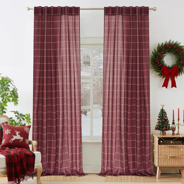 Burgundy plaid back tab curtains hanging on a silver rod, framing a window with a snowy winter view.