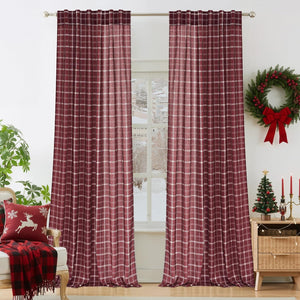 Pair of rich burgundy plaid window curtains with white lines, hung in a festive room.