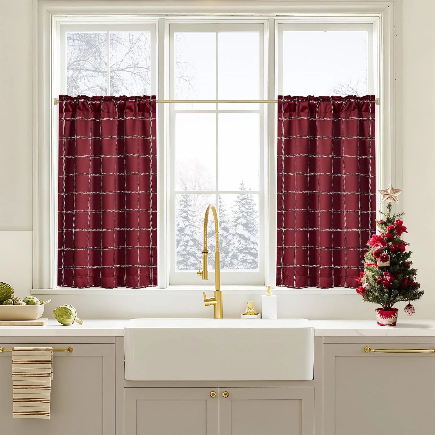 Burgundy plaid tier curtains over a white kitchen sink with brass faucet