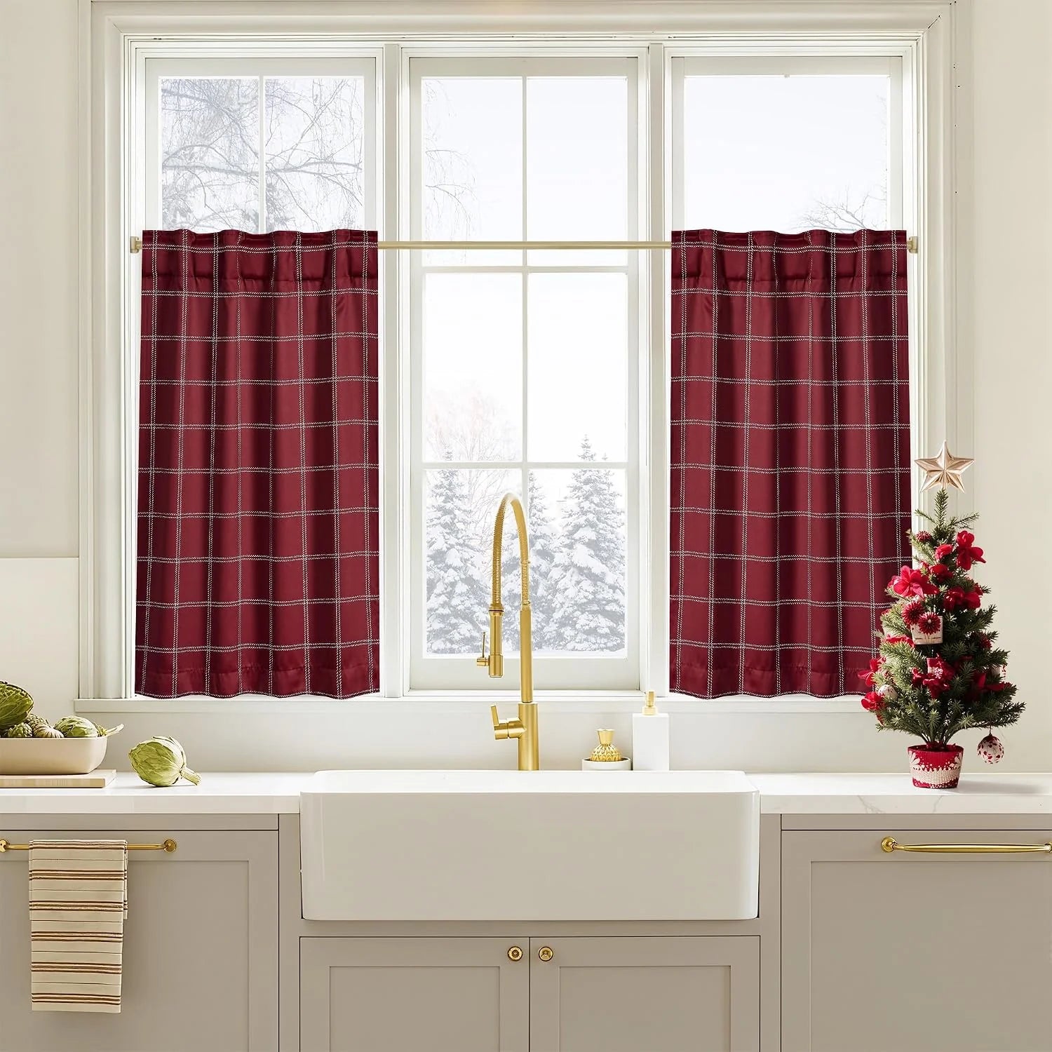 Burgundy plaid tier curtains over a bright kitchen sink window with gold faucet