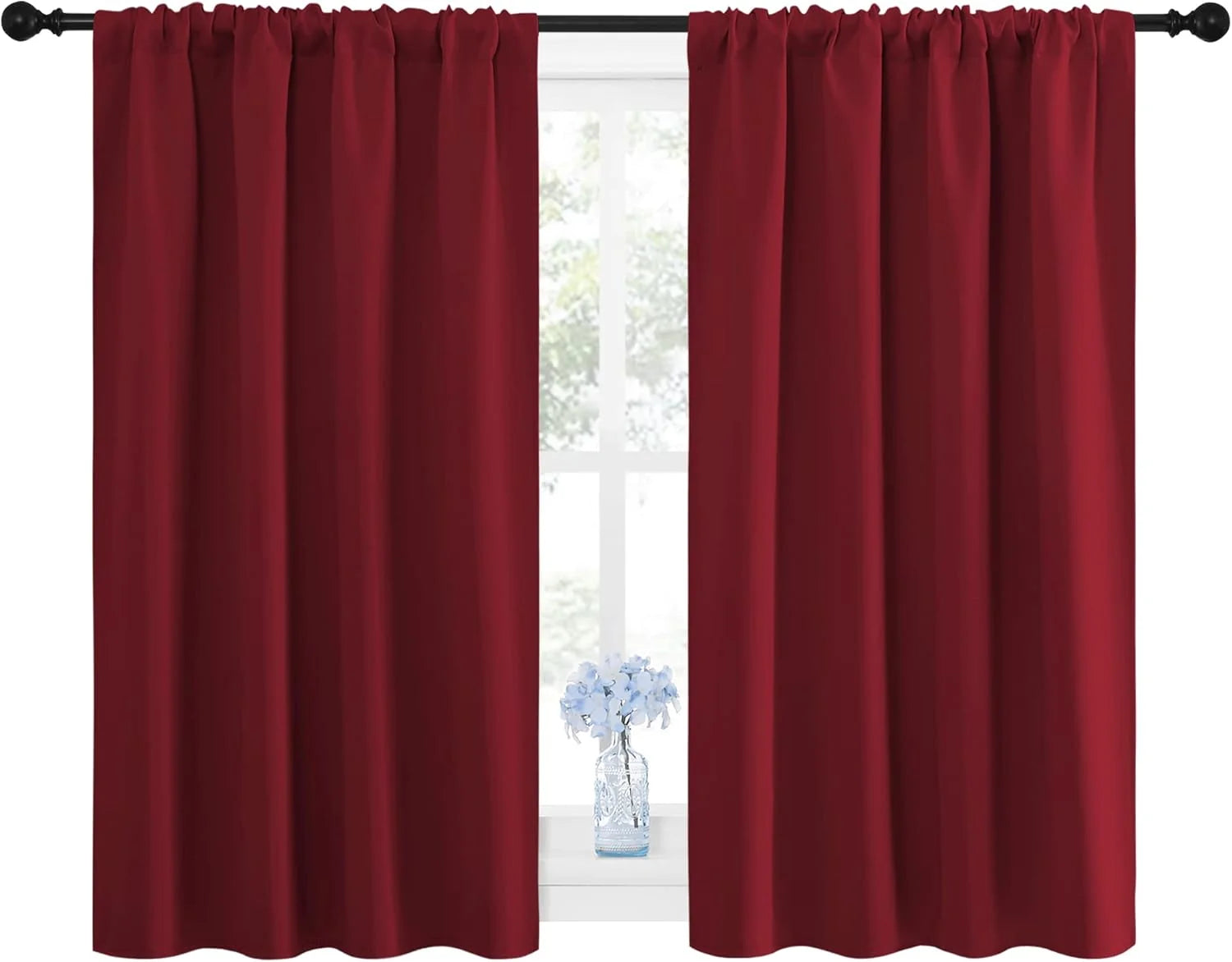 Pair of dark red rod pocket curtains covering a window, with a small vase of blue flowers on the sill.