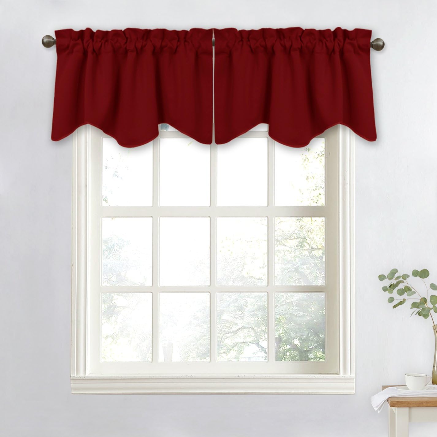 Burgundy scalloped rod pocket valance draped on a metal rod above a white window frame.