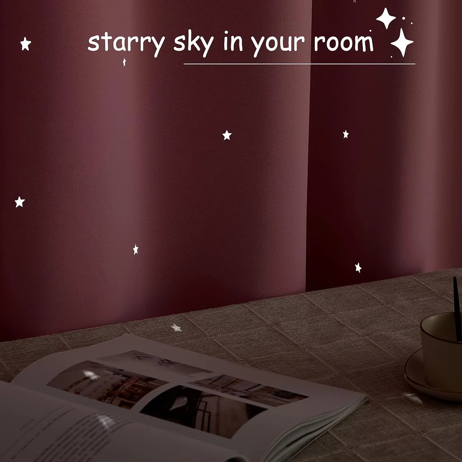 Burgundy curtain panel with tiny glowing star cutouts beside a cozy table setting