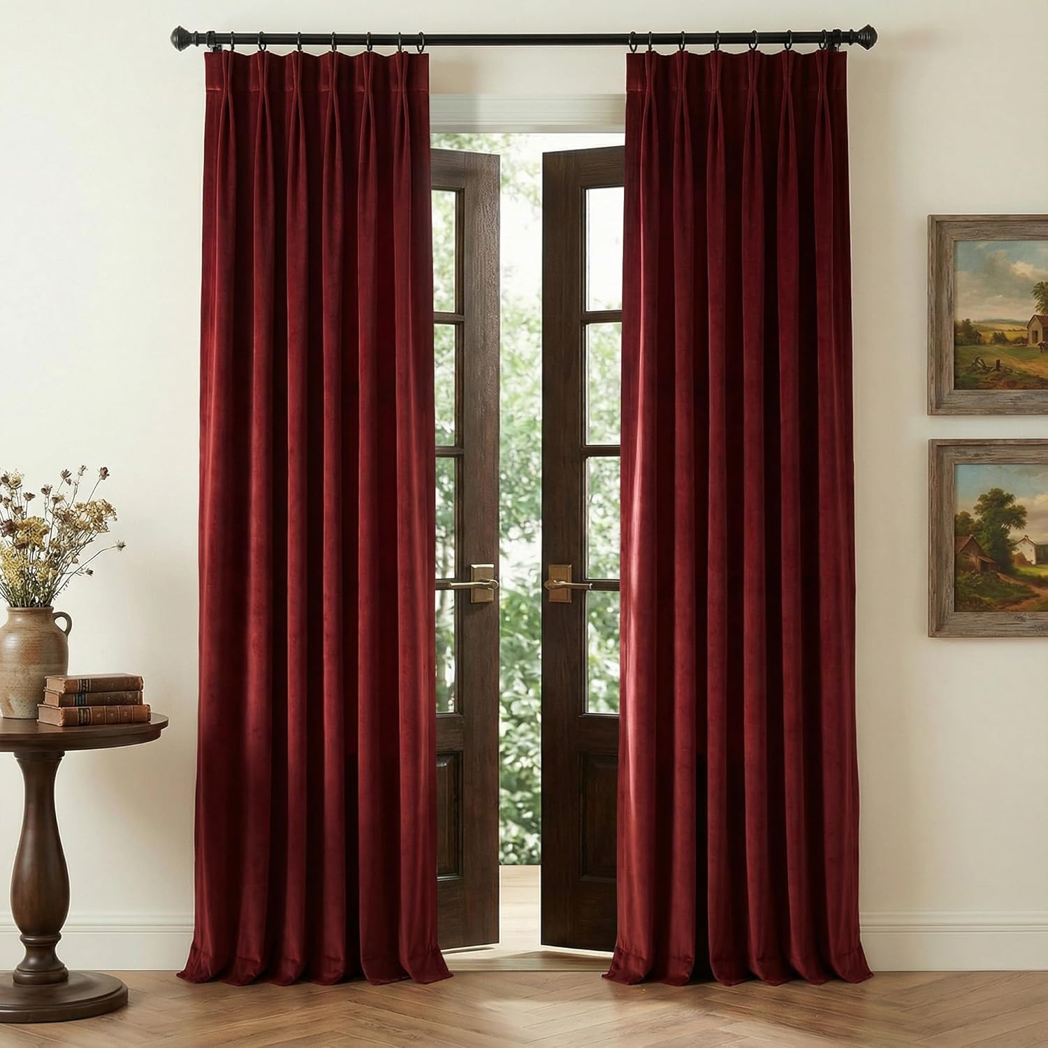 Luxurious burgundy velvet pinch pleat curtains on a black rod, next to open French doors.