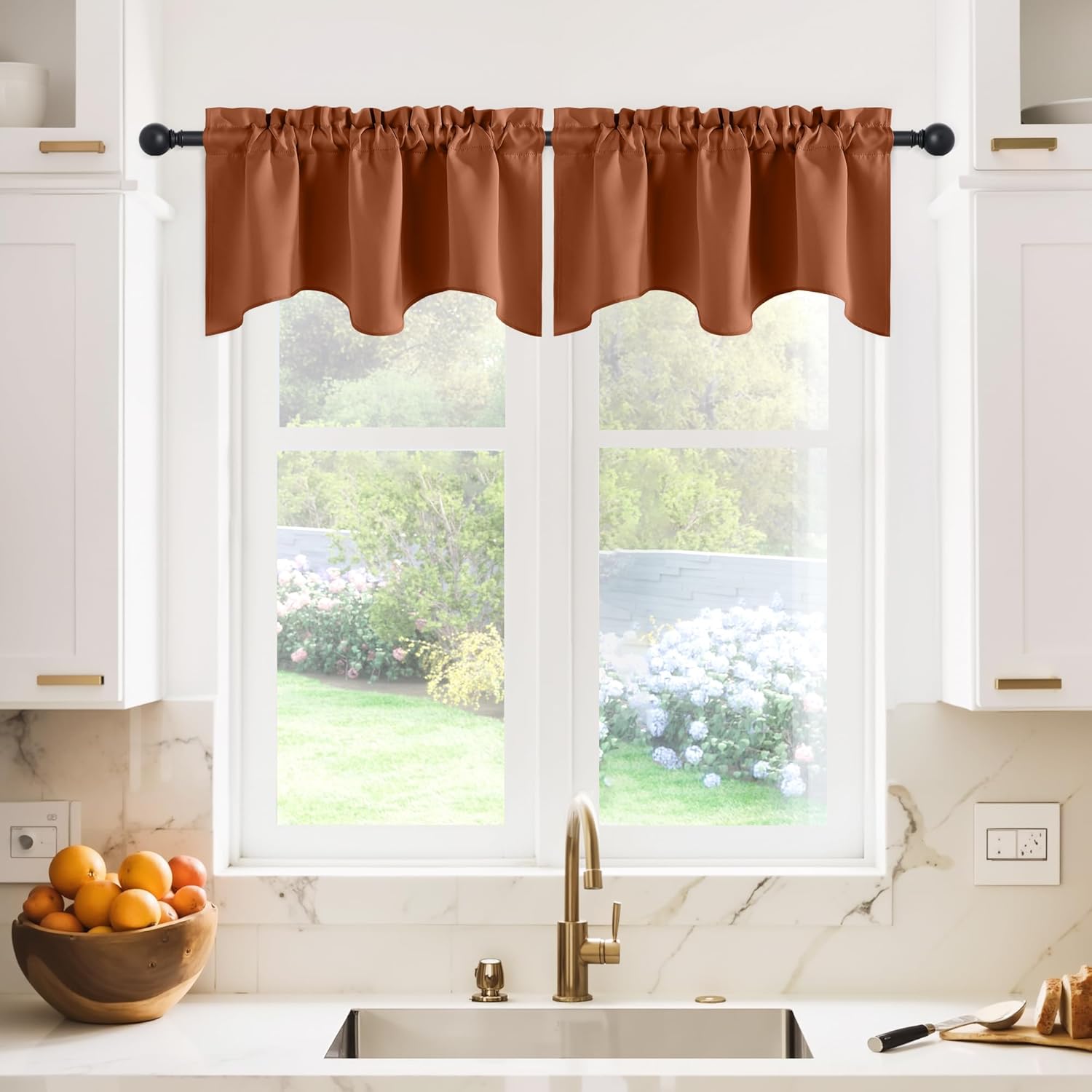 Burnt orange scalloped valance curtains with gathered top on black rod over kitchen window.