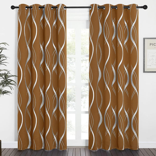 A pair of burnt orange curtains with silver wavy patterns and grommet tops hanging on a black rod.
