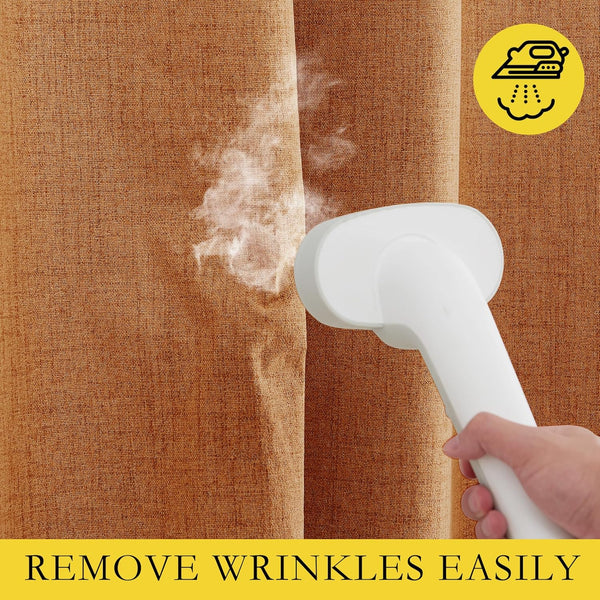 A hand holds a white steamer, removing wrinkles from a burnt orange, textured linen curtain.