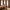 Burnt sienna textured pinch pleat curtains on a black rod framing arched windows in a warm bedroom.
