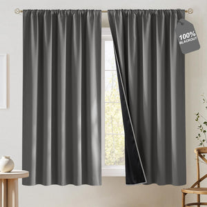 Charcoal gray blackout curtains with rod pocket top, one curtain open revealing dark lining.