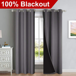 Charcoal gray grommet blackout curtains, one panel open showing black lining, hanging on a window rod.