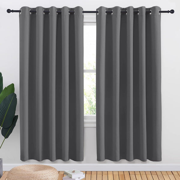 Pair of charcoal gray blackout curtains with metal grommet tops, hung on a black rod over a window.