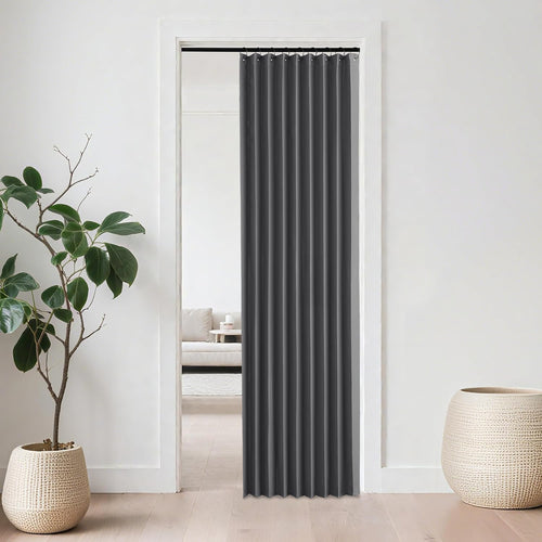 Charcoal grey accordion room divider curtain with grommet top in a modern doorway.