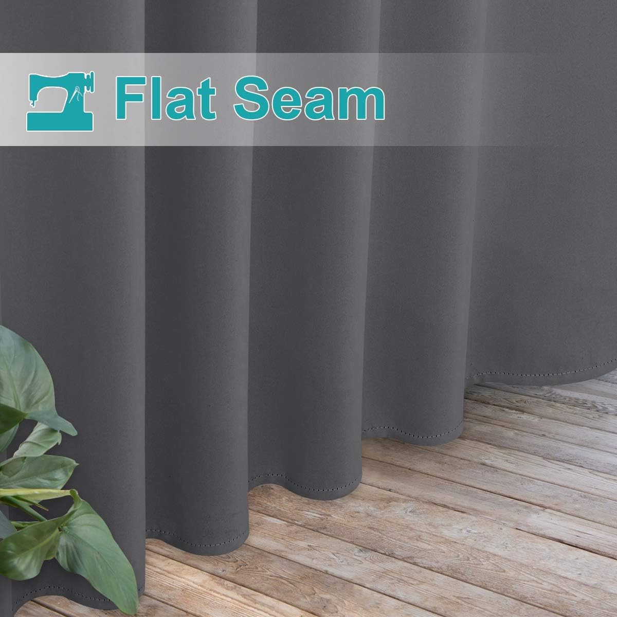 Charcoal grey blackout curtains with visible flat seam detail, hanging over a wooden floor.