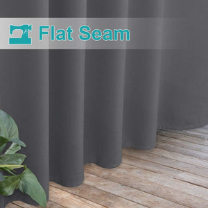 Charcoal grey blackout curtains with visible flat seam detail, hanging over a wooden floor.