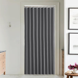 Full-length charcoal grey privacy curtain hanging from a silver rod with hooks, covering an interior doorway.