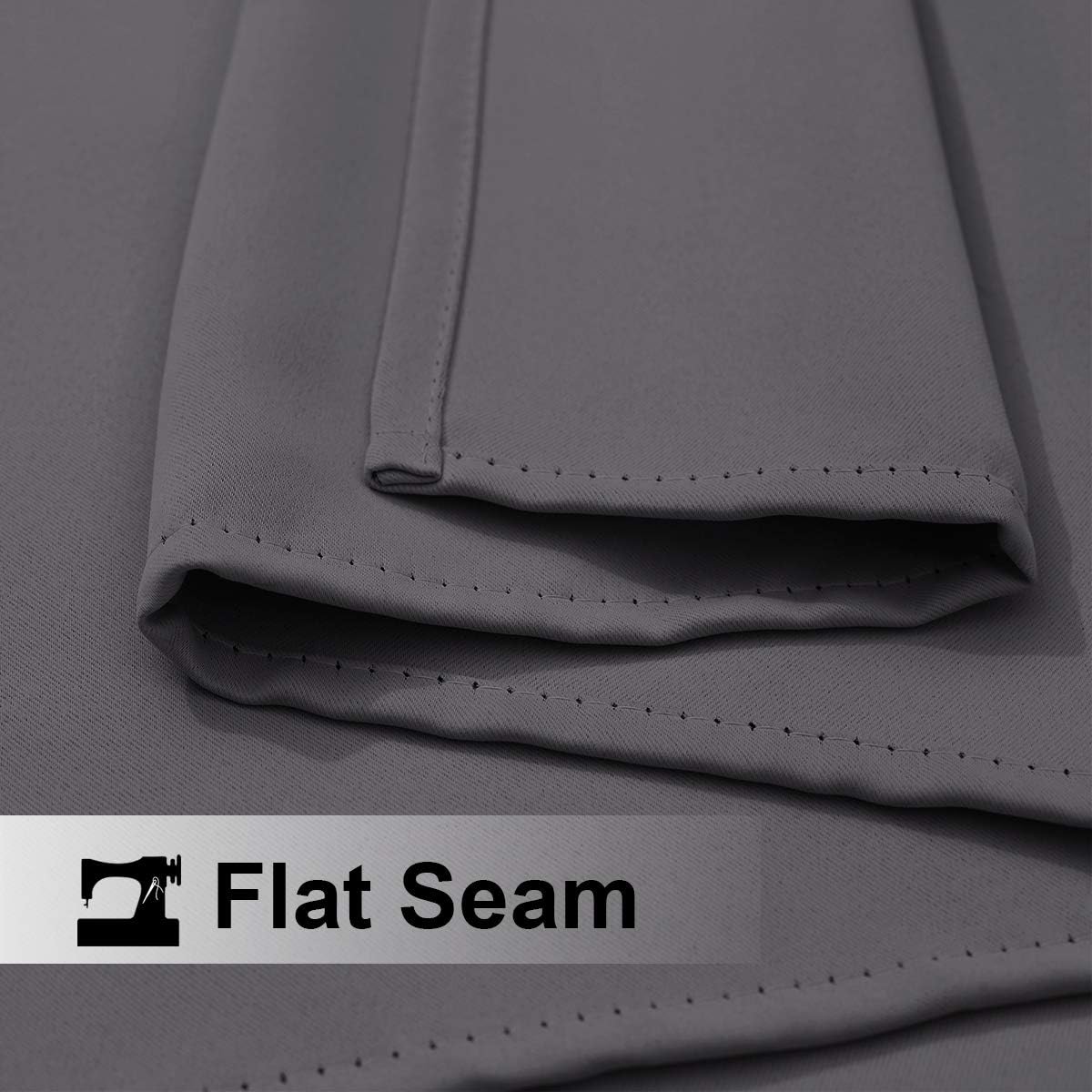 Close-up of charcoal grey woven fabric showing a clean flat seam with even stitching along the folded edge.