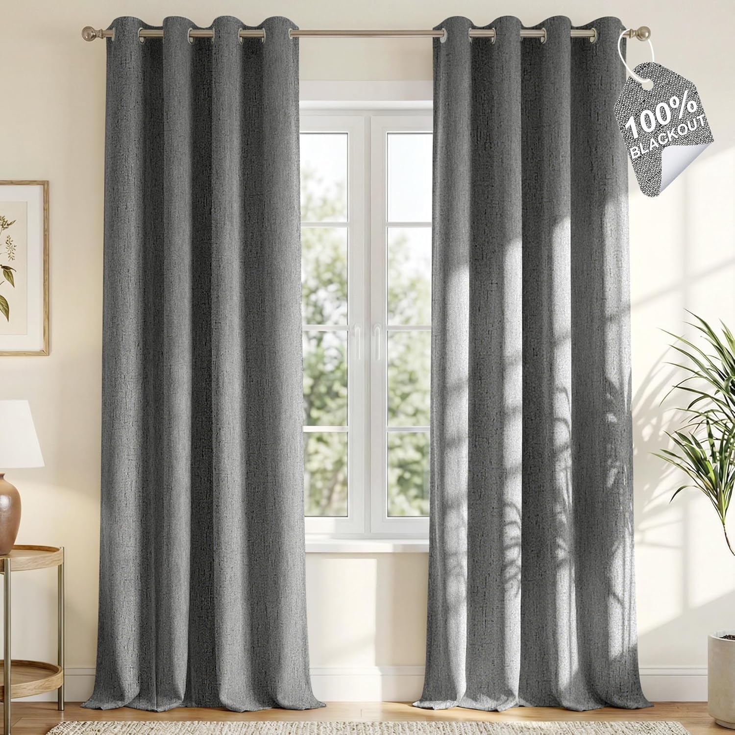 Charcoal grey textured 100% blackout curtains with grommet top hanging on a rod over a window.