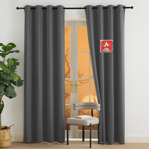 Charcoal gray grommet top curtains, labeled flame retardant, hanging over a sunny glass door.