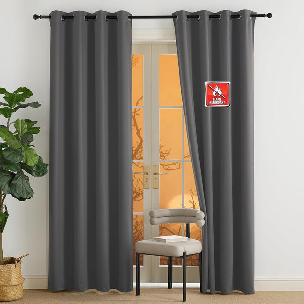 Charcoal gray grommet top curtains, labeled flame retardant, hanging over a sunny glass door.