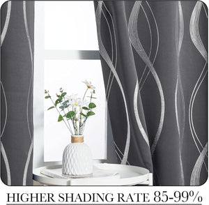 Modern charcoal blackout curtains with abstract silver wavy lines. Hanging on a bright window.