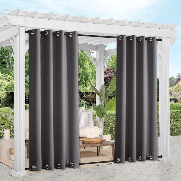 Charcoal gray outdoor privacy curtains with metal grommets, hanging on a white pergola.