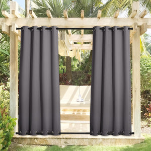 Charcoal gray outdoor patio curtains with top and bottom grommets hanging on a wooden pergola.