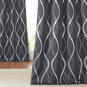 Dark gray window curtains with vertical silver wavy abstract patterns. Hung in front of a sunlit window.