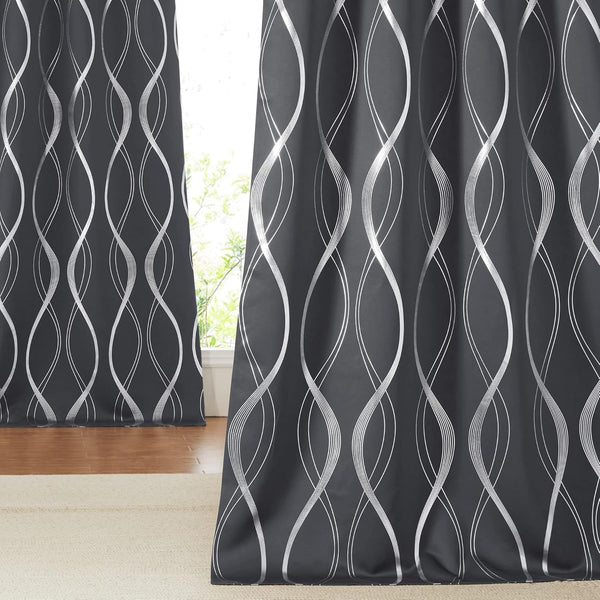 Dark gray window curtains with vertical silver wavy abstract patterns. Hung in front of a sunlit window.
