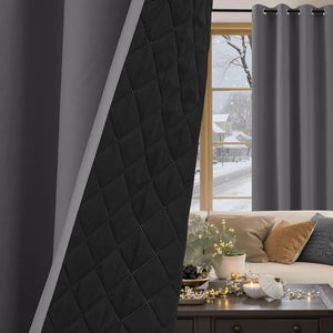 Dark gray thermal blackout curtains with grommet top and visible quilted black lining. Window shows snowy scene.