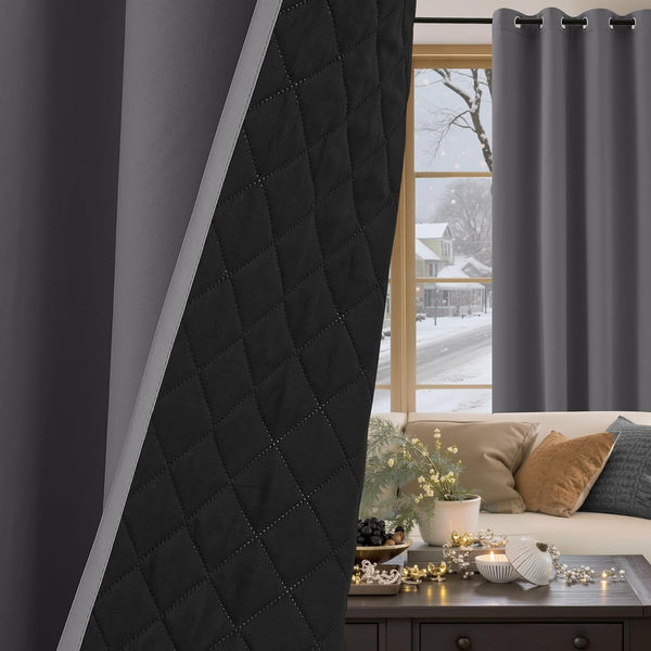 Dark gray thermal blackout curtains with grommet top and visible quilted black lining. Window shows snowy scene.