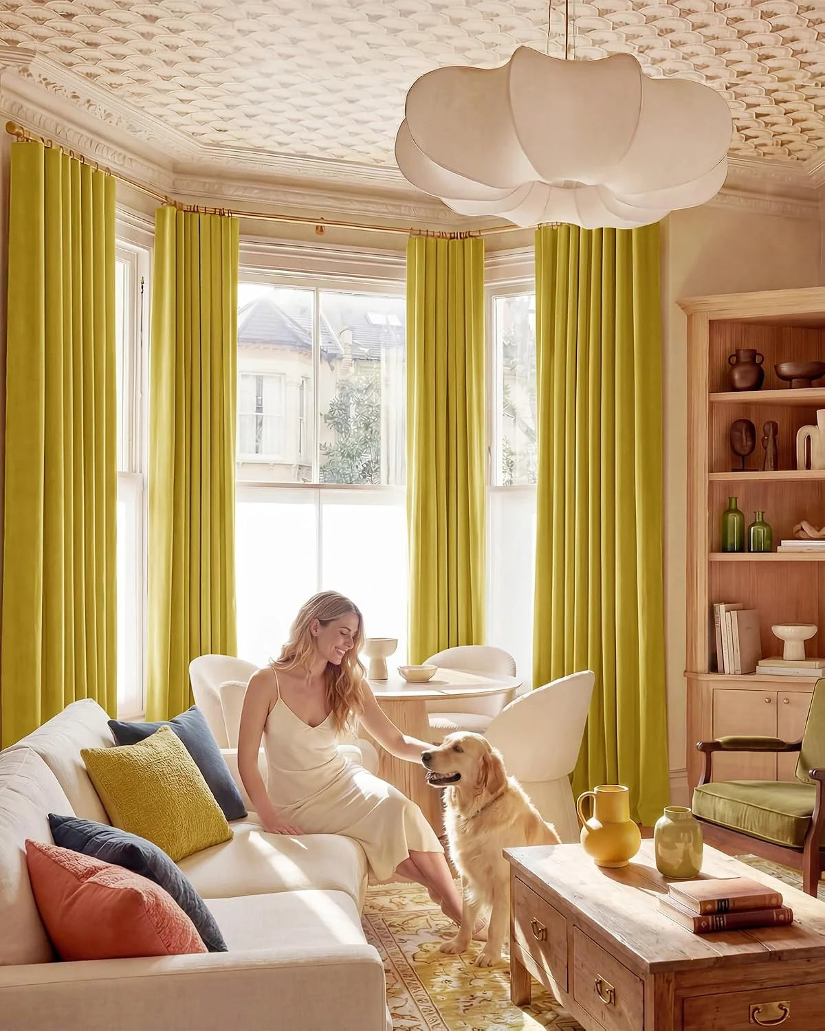 Chartreuse pleated curtains in a bright traditional living room with a woman and golden retriever