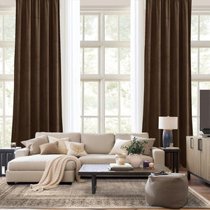 Chocolate brown velvet blackout curtains with elegant pleats frame a large window in a modern living room.