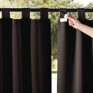 Dark brown outdoor tab top curtain, a hand shows the hook and loop closure on one tab.