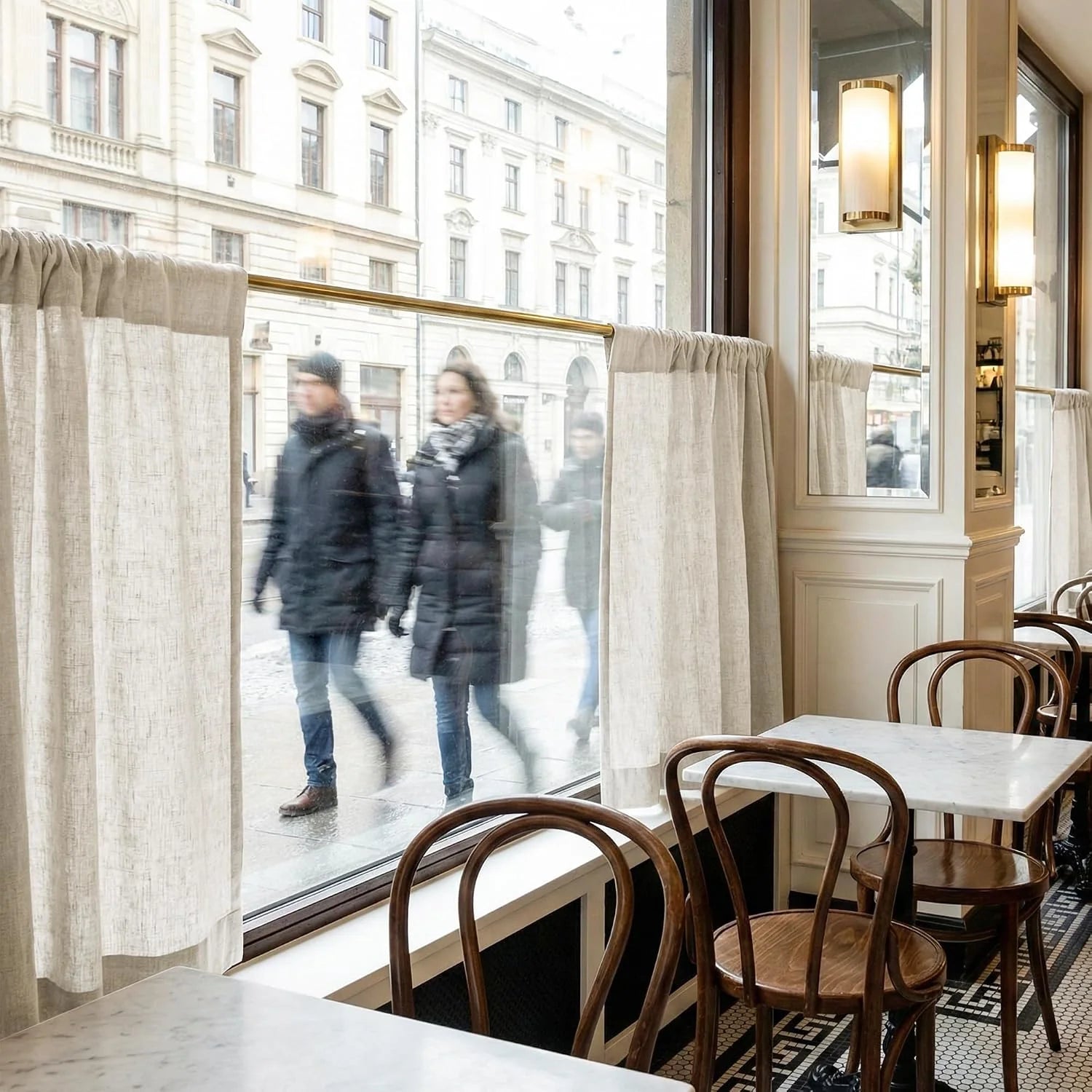 Classic cafe interior with linen curtains, marble tables, wooden chairs, and a bustling street view outside.