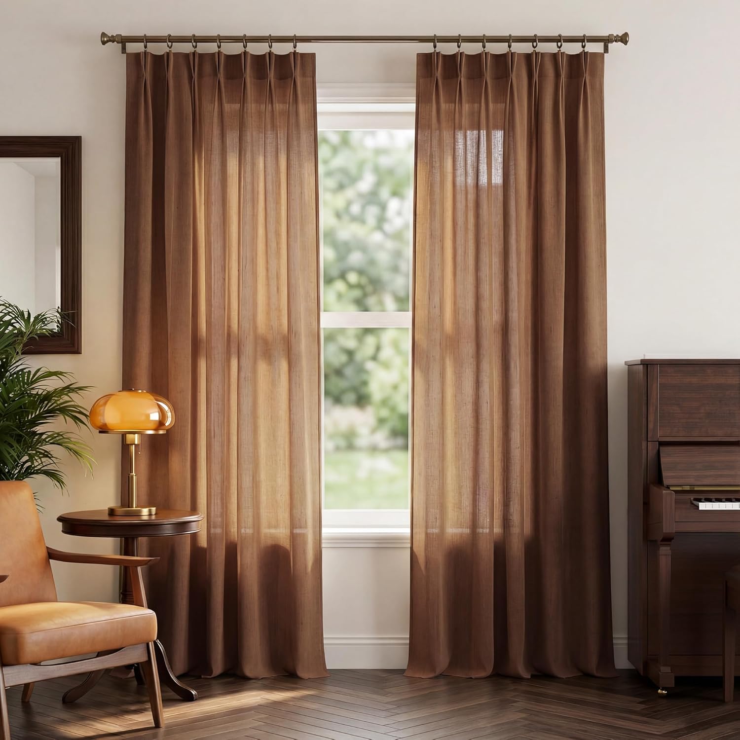 Pair of cocoa brown linen-blend curtains with pinch pleats, hung on a brass rod, framing a sunlit window.