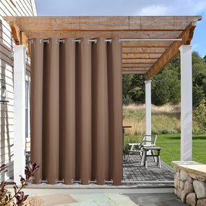 Coffee brown outdoor curtain with silver grommets hangs from a pergola, providing patio privacy.