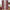 Cranberry red window curtains with white plaid pattern, rod pocket top, hanging on a silver rod.