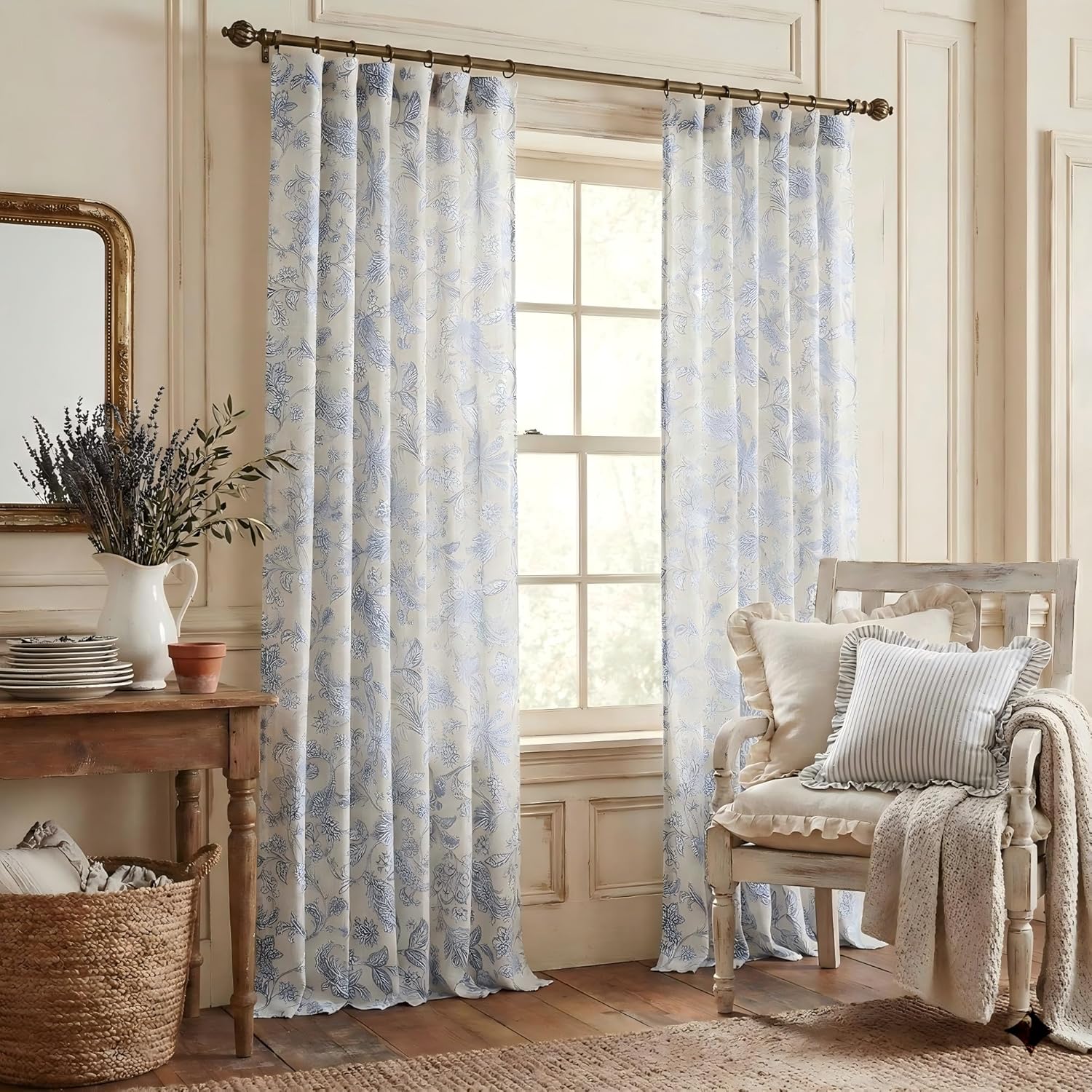 Light cream curtains with blue botanical print hanging on a decorative rod, adding a rustic, airy feel.