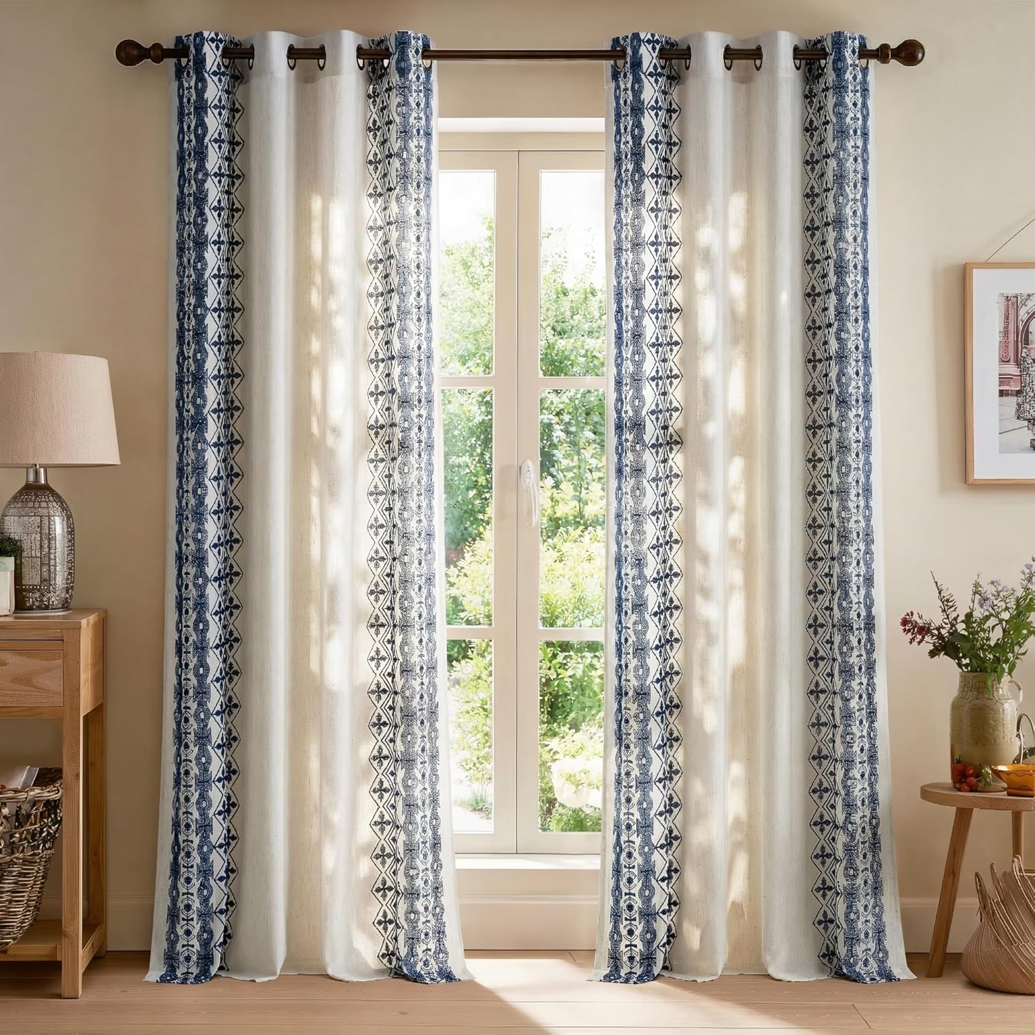 Light-filtering cream curtains with deep blue bohemian patterned borders and metal grommet tops.