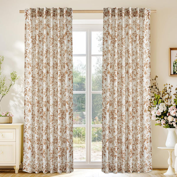 Pair of cream tab top curtains with brown vintage floral print over window.