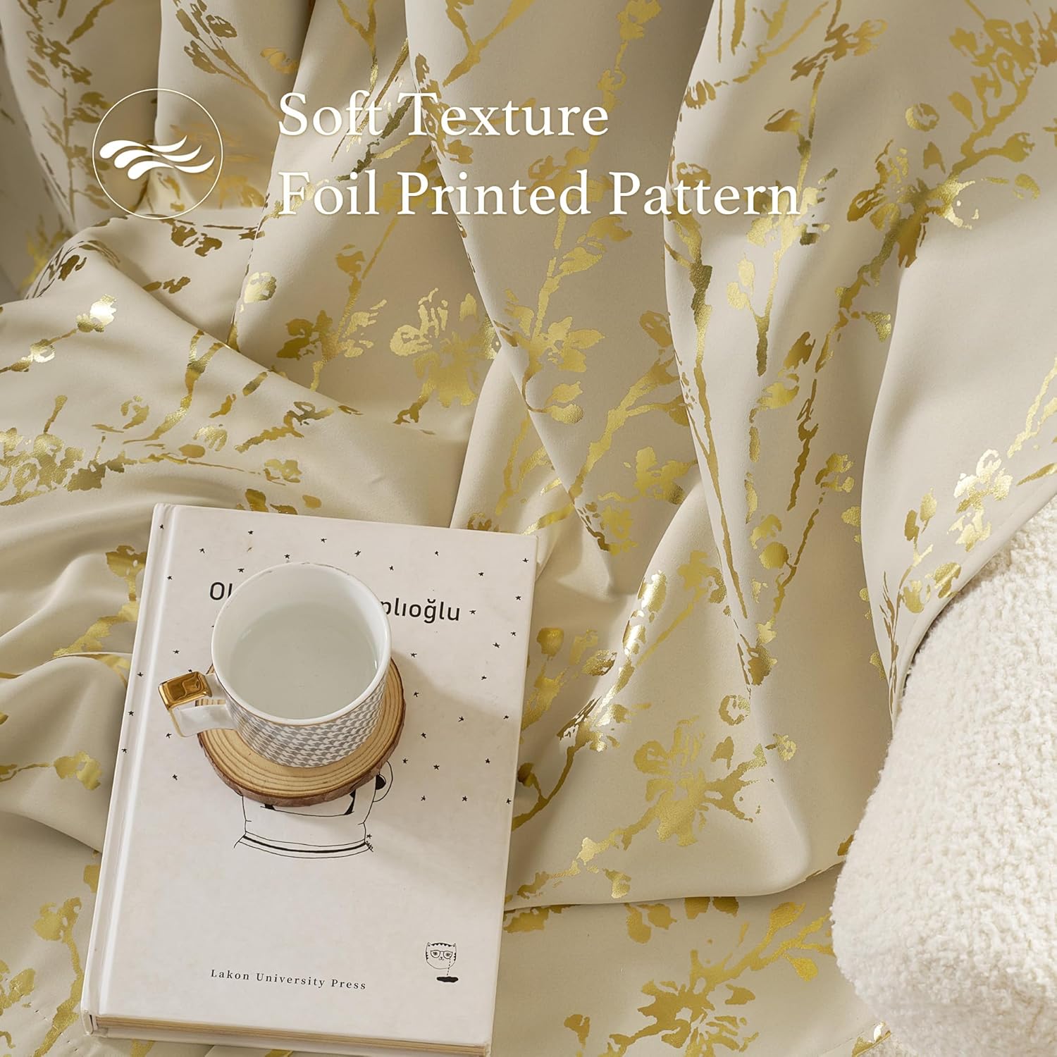 Soft cream fabric with shimmering gold foil floral pattern, elegantly draped for display.