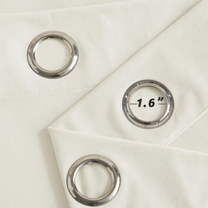 Close-up of cream-colored curtain fabric with shiny silver grommet rings, one showing a 1.6-inch inner diameter.