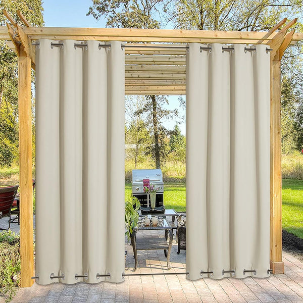 Cream outdoor patio curtains with silver grommets hanging on a wooden pergola for privacy and shade.