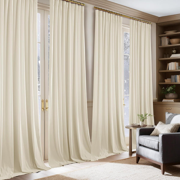 Cream pleated drapes hanging from a brass rod over tall glass doors in a cozy room.