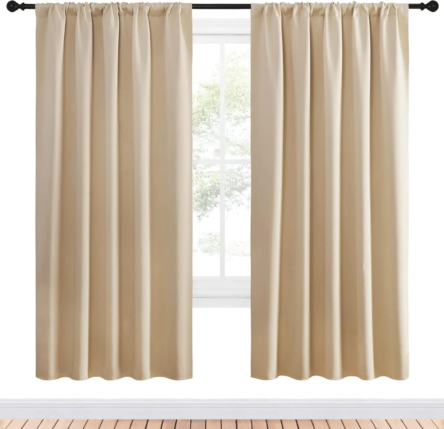 Cream rod pocket curtains hanging on a black curtain rod over a bright window