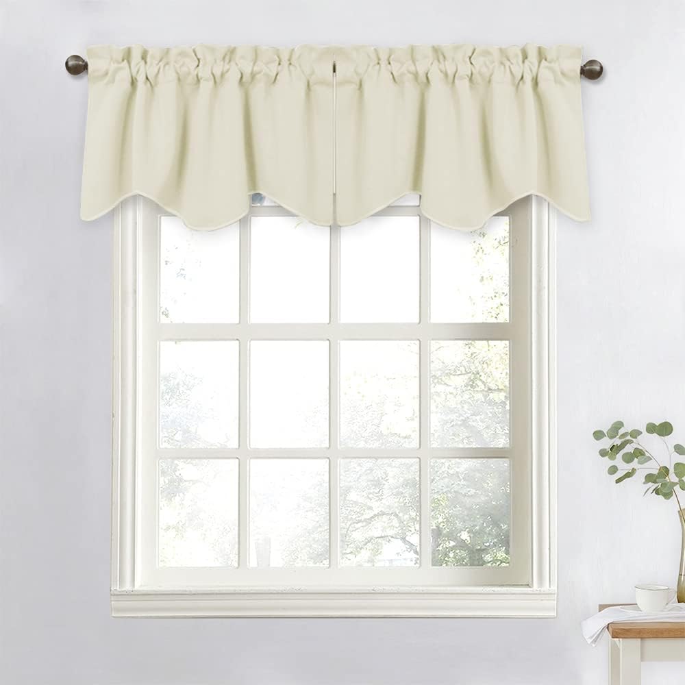 Cream-colored window valance with a decorative scalloped bottom edge and gathered rod pocket, hung above a window.